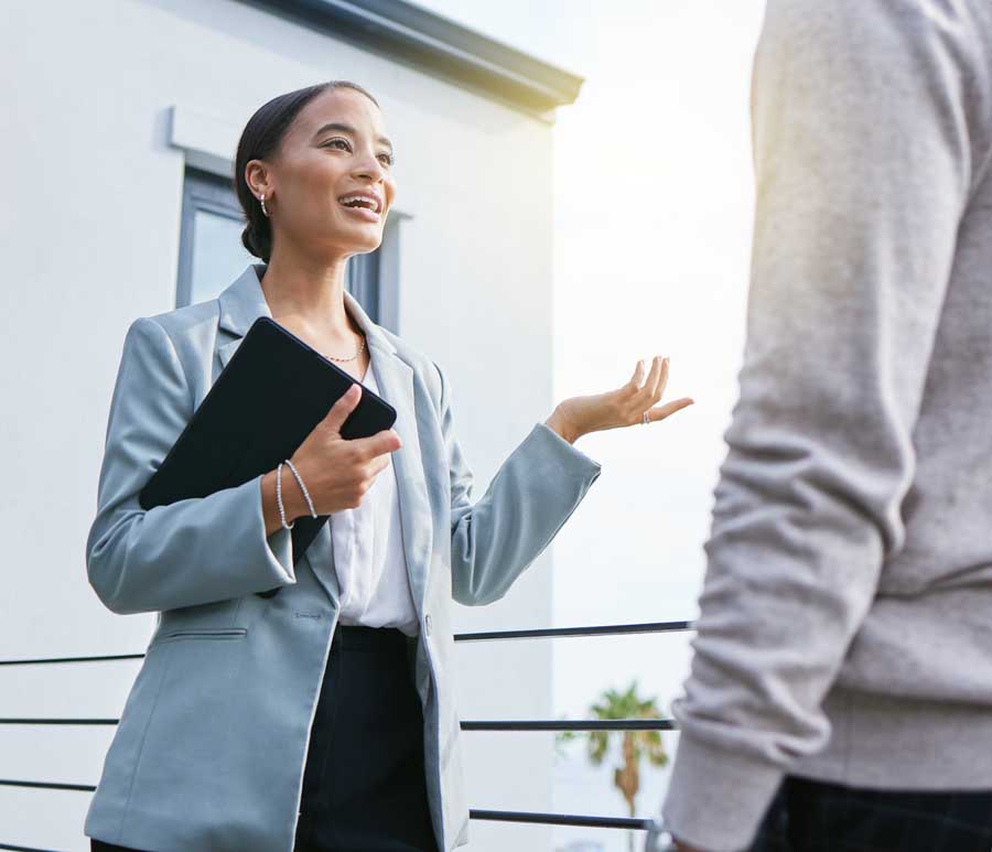 Shot of a young female real estate agent showing a client a house.