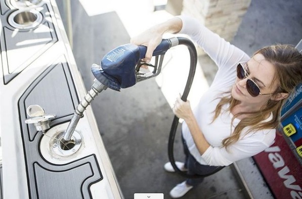 Woman at a gas pump filling up a boat