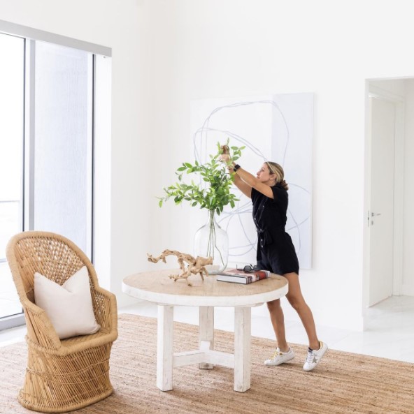 Someone staging a home, focusing on a table centerpiece.