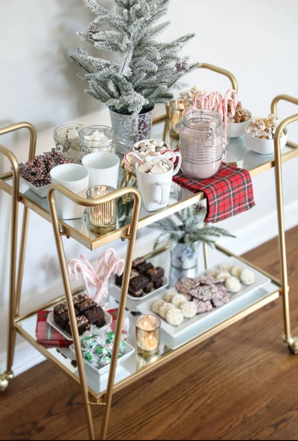 Bar cart with trays and bowls of candy and treats on both levels.