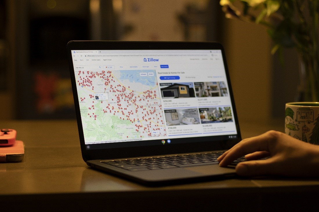 Someone searching for a home on Zillow on their laptop.