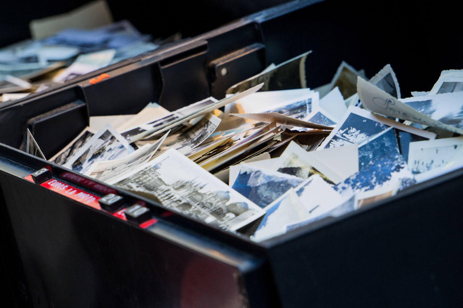 Piles of photos haphazardly placed in a bin