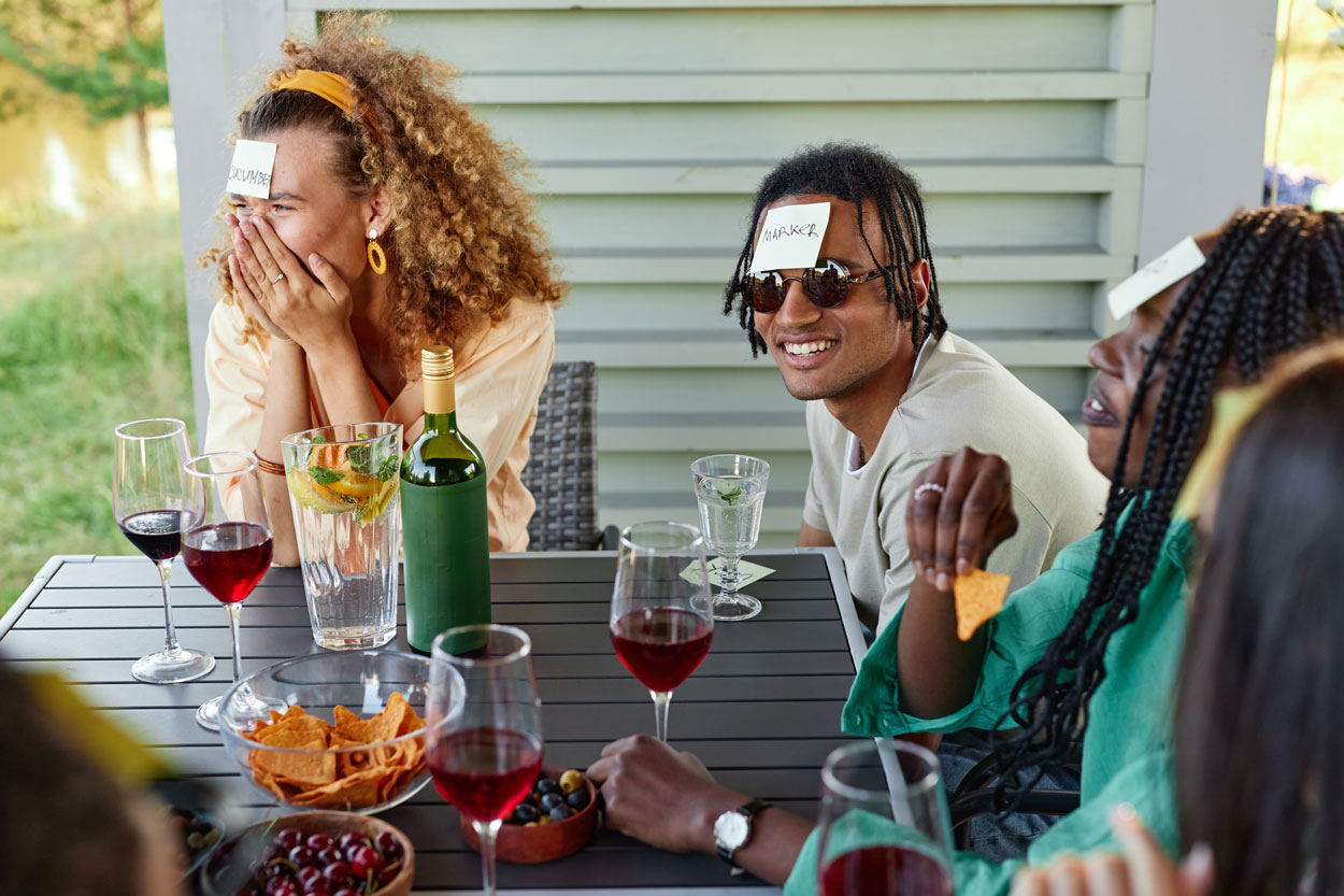Group of adults playing a game of Guess Word at a picnic